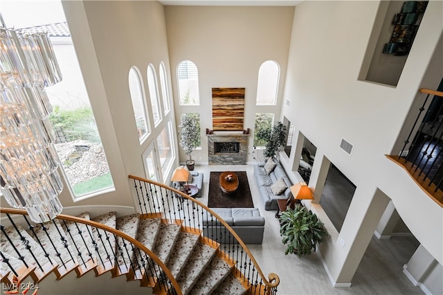 interior space featuring a high ceiling, a stone fireplace, and hardwood / wood-style flooring