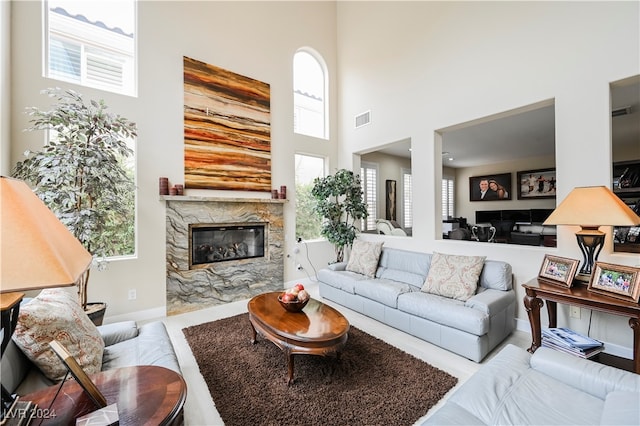 living room with a premium fireplace and a high ceiling