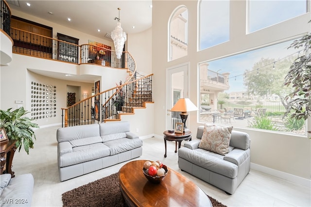 living room with a high ceiling, a wealth of natural light, and a notable chandelier