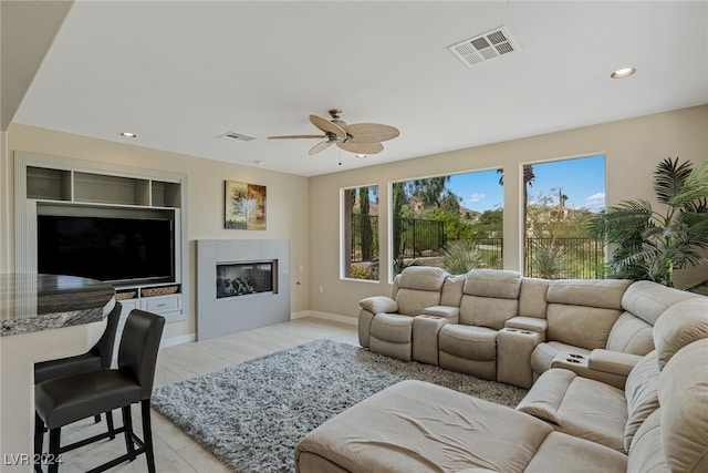 living room with ceiling fan and light tile patterned flooring