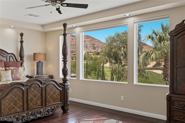 bedroom featuring dark wood-type flooring, a mountain view, and ceiling fan