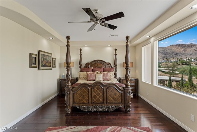 bedroom featuring dark wood-type flooring, a mountain view, and ceiling fan