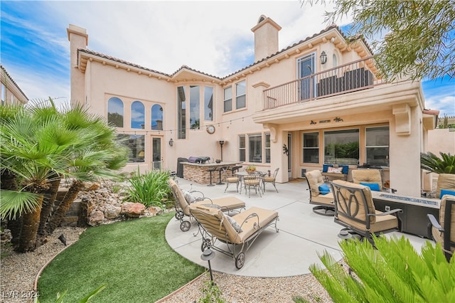 back of property featuring an outdoor hangout area, a patio area, and a balcony