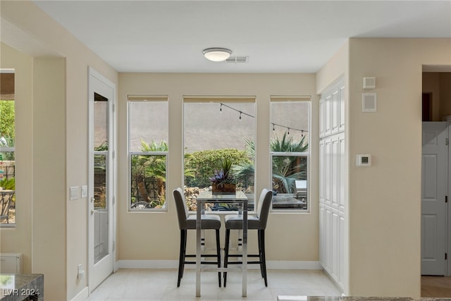 dining area with light tile patterned flooring and plenty of natural light