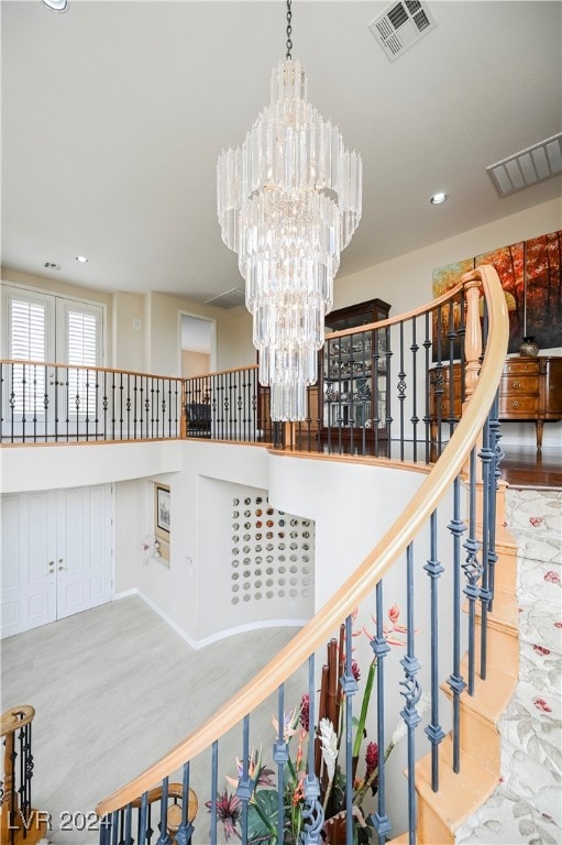 stairs featuring hardwood / wood-style floors and a notable chandelier