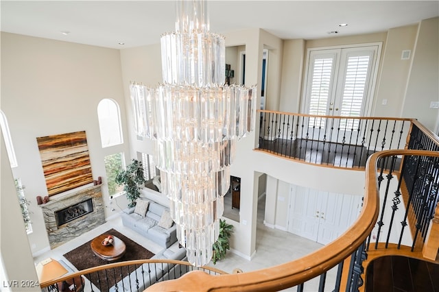 interior space featuring a fireplace, a chandelier, french doors, and light hardwood / wood-style flooring