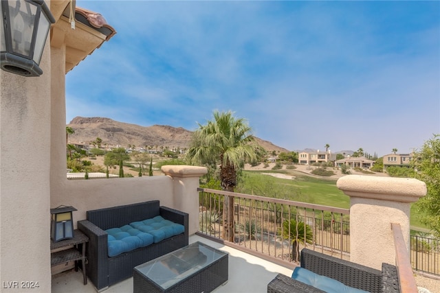 view of patio with an outdoor living space, a mountain view, and a balcony