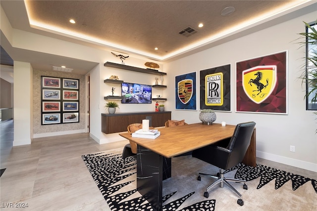 office space featuring a textured ceiling and a tray ceiling