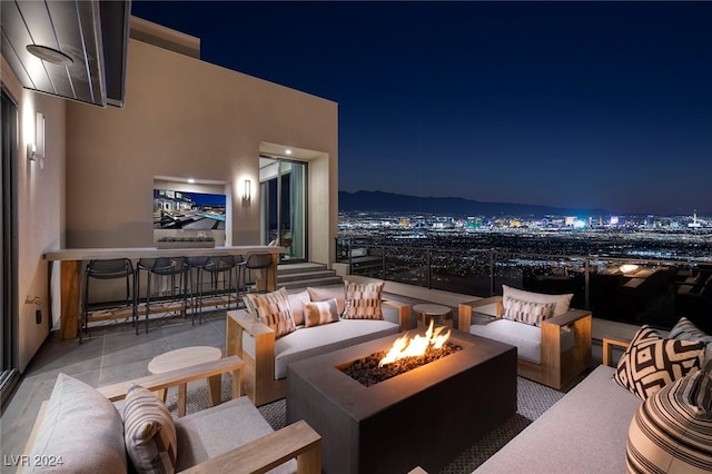 patio at twilight featuring an outdoor living space with a fire pit