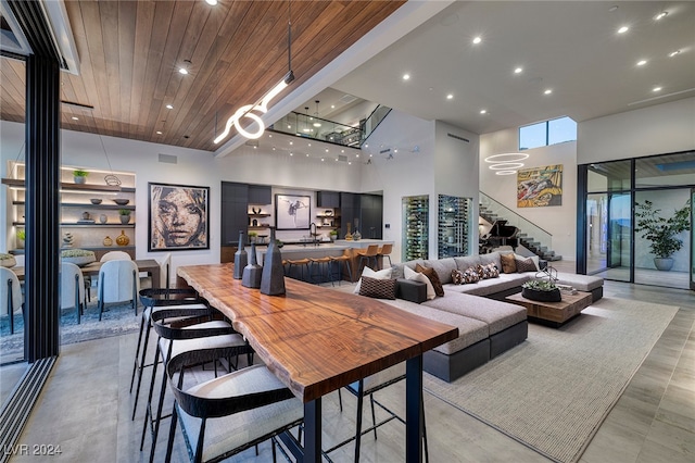 dining room featuring a chandelier, a high ceiling, and wooden ceiling