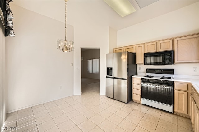 kitchen featuring gas range, stainless steel fridge, a chandelier, pendant lighting, and light tile patterned floors