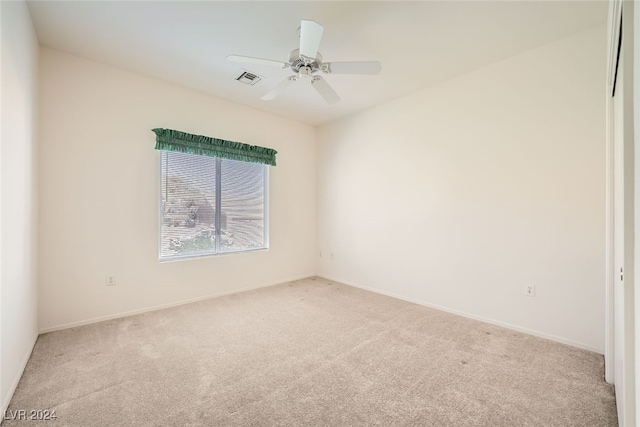 carpeted spare room with ceiling fan