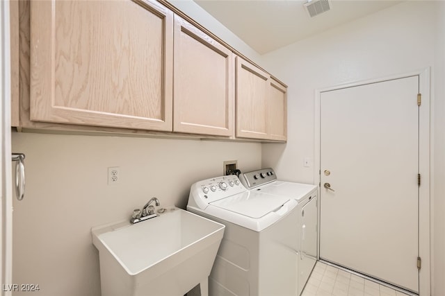 laundry area with washing machine and dryer, sink, and cabinets