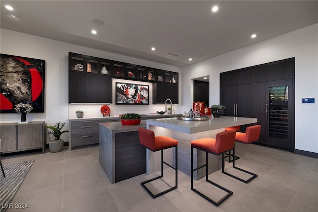 bar with wine cooler and light tile patterned floors