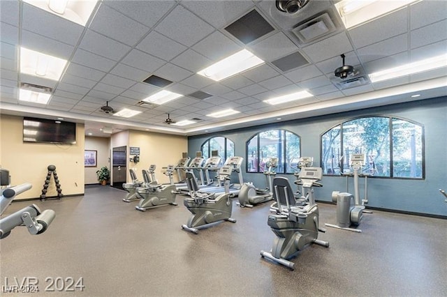 exercise room featuring a drop ceiling, visible vents, and baseboards