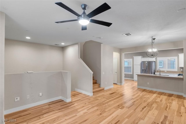 interior space with baseboards, visible vents, a sink, and light wood finished floors