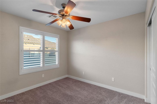 empty room featuring carpet, visible vents, baseboards, and ceiling fan