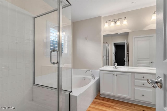 full bathroom with vanity, a stall shower, wood finished floors, and a bath