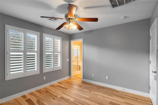 unfurnished room featuring a ceiling fan, visible vents, baseboards, and wood finished floors