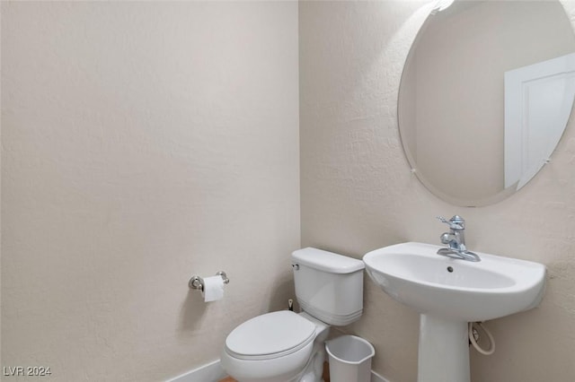 bathroom with toilet and baseboards