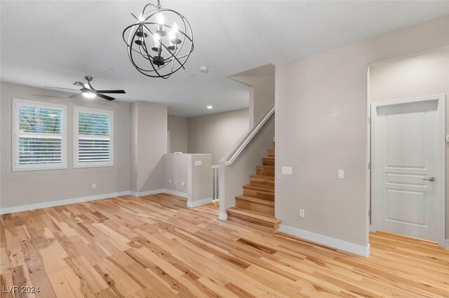 empty room with light wood finished floors, stairs, and baseboards