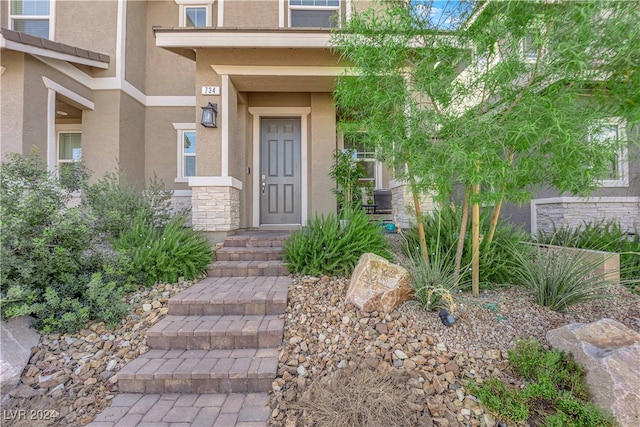 property entrance featuring stone siding and stucco siding