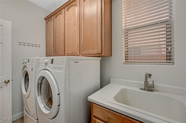 laundry area featuring washer and dryer, sink, and cabinets