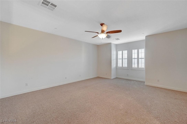 empty room featuring ceiling fan and light colored carpet