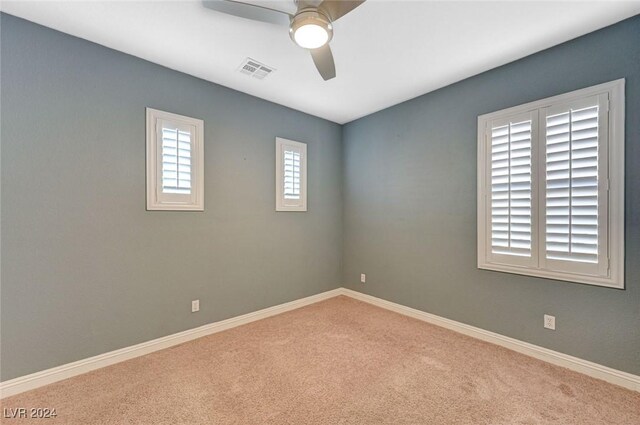 carpeted spare room with ceiling fan