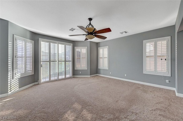 unfurnished room with light colored carpet and ceiling fan