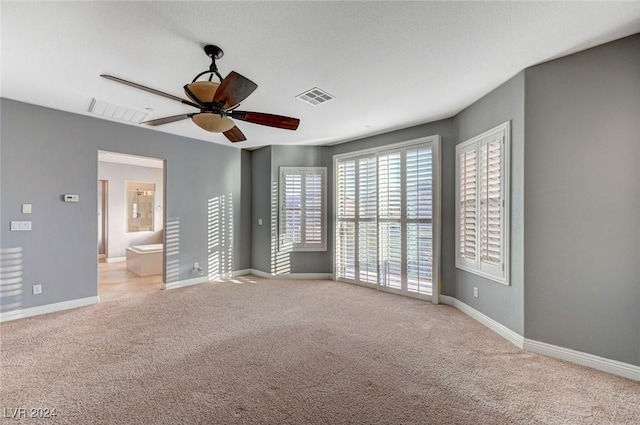 unfurnished bedroom with light carpet, ceiling fan, and ensuite bathroom