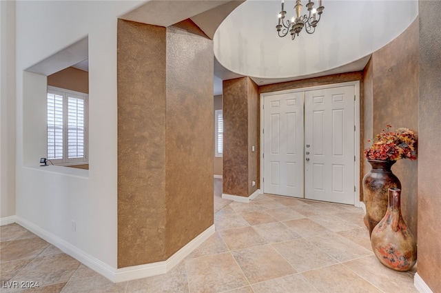 entryway with a chandelier and light tile patterned flooring