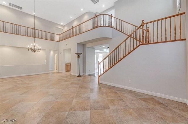 unfurnished living room featuring a towering ceiling