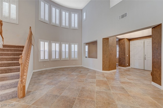 unfurnished living room with a towering ceiling