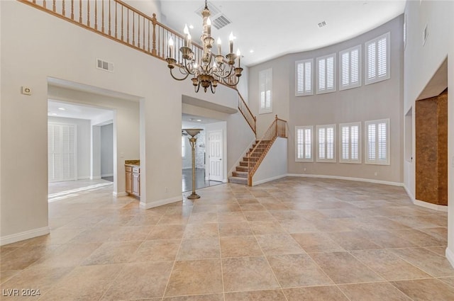 unfurnished living room with a high ceiling and an inviting chandelier