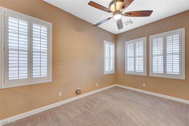 carpeted spare room featuring ceiling fan