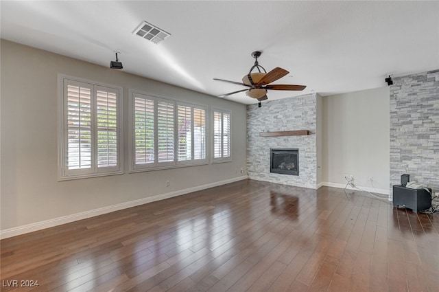 unfurnished living room with dark hardwood / wood-style flooring, ceiling fan, and a fireplace