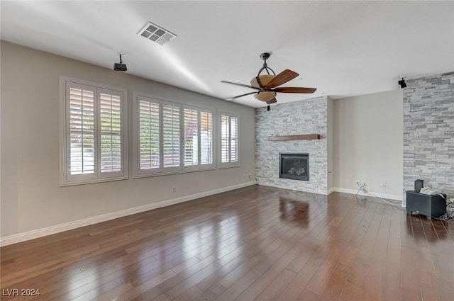 unfurnished living room featuring dark wood-type flooring, ceiling fan, and a fireplace