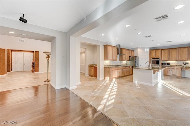 unfurnished living room with sink and light hardwood / wood-style floors