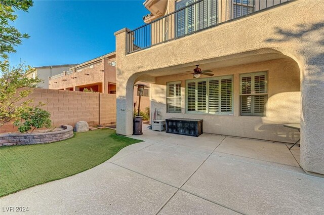 view of patio with ceiling fan and a balcony