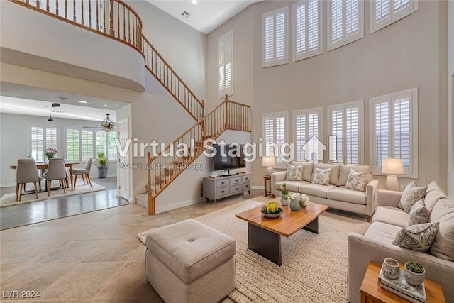 living room with a high ceiling and ceiling fan