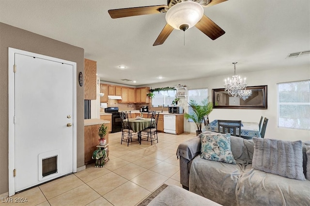 tiled living room featuring ceiling fan with notable chandelier