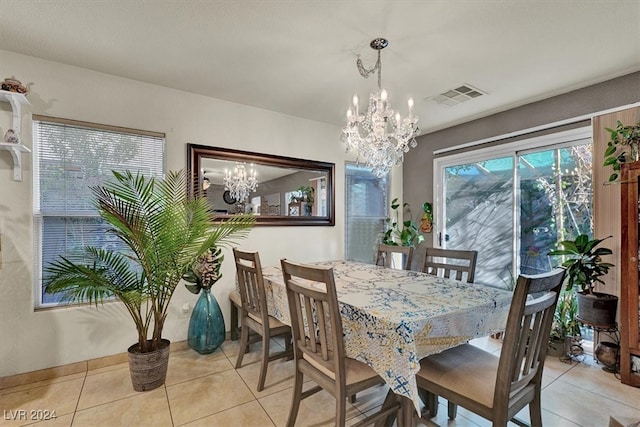 dining room with light tile patterned floors and a notable chandelier