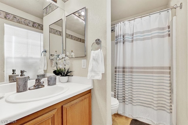 full bathroom featuring toilet, vanity, and shower / bathtub combination with curtain