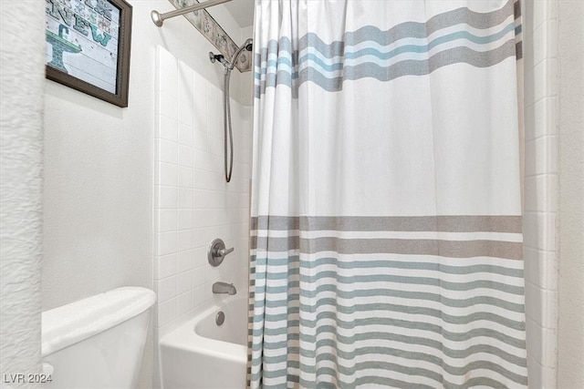 bathroom featuring shower / bathtub combination with curtain and toilet