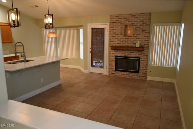 kitchen featuring tile patterned flooring, a kitchen breakfast bar, and decorative light fixtures