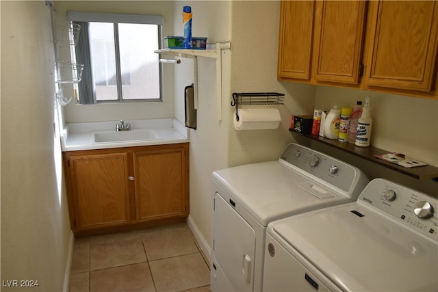 laundry area featuring light tile patterned flooring, washer and clothes dryer, cabinets, and sink