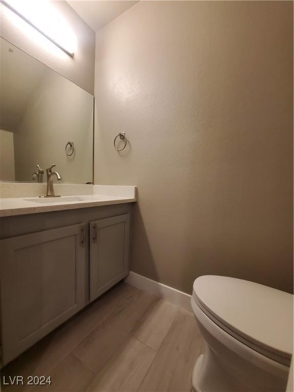 bathroom featuring hardwood / wood-style flooring, vanity, and toilet