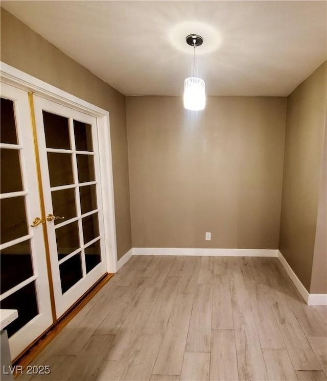 unfurnished dining area with light hardwood / wood-style flooring and french doors