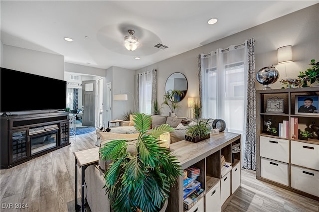 living room with ceiling fan and light hardwood / wood-style flooring